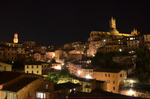 Old town Siena and the Duomo lit up at night.